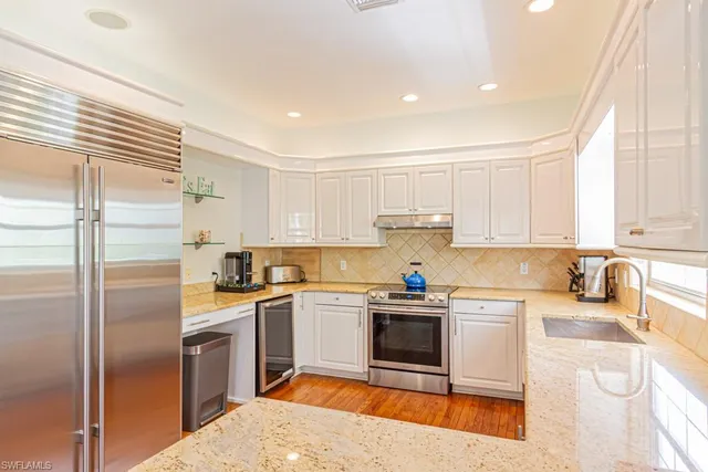 a kitchen with a sink a refrigerator and cabinets