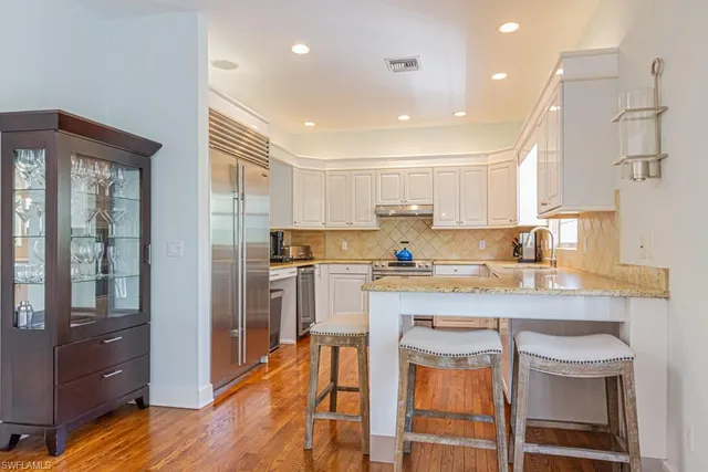 a kitchen with stainless steel appliances granite countertop a stove top oven a sink and cabinets