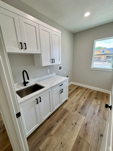 1184 West 3250 North Ogden, UT 84414 - Photo 48 of 69 Laundry area featuring white shaker-style cabinetry, a stainless steel undermount sink with a matte black faucet, and a white quartz countertop with subtle gray veining