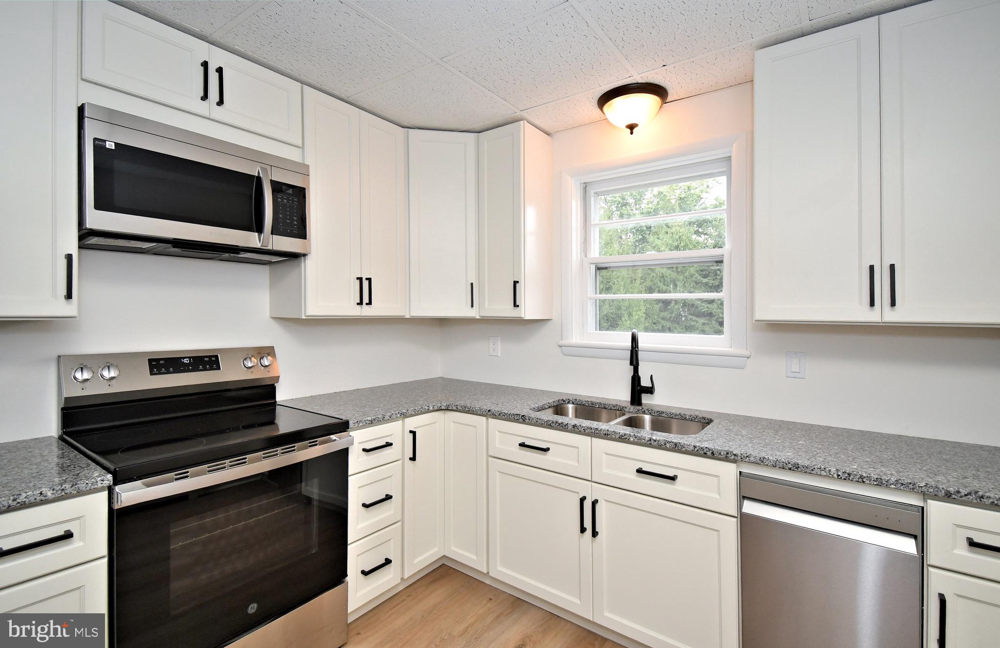 4776 Old Easton Road, Unit 2 Doylestown, PA 18902 - Photo 6 of 25 a kitchen with cabinets stainless steel appliances and a window