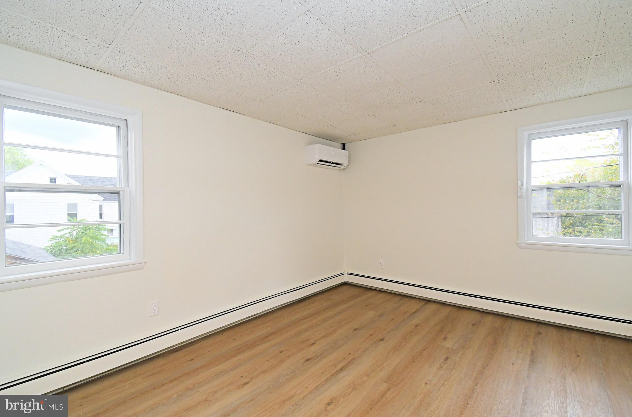 4776 Old Easton Road, Unit 2 Doylestown, PA 18902 - Photo 8 of 25 an empty room with wooden floor and windows