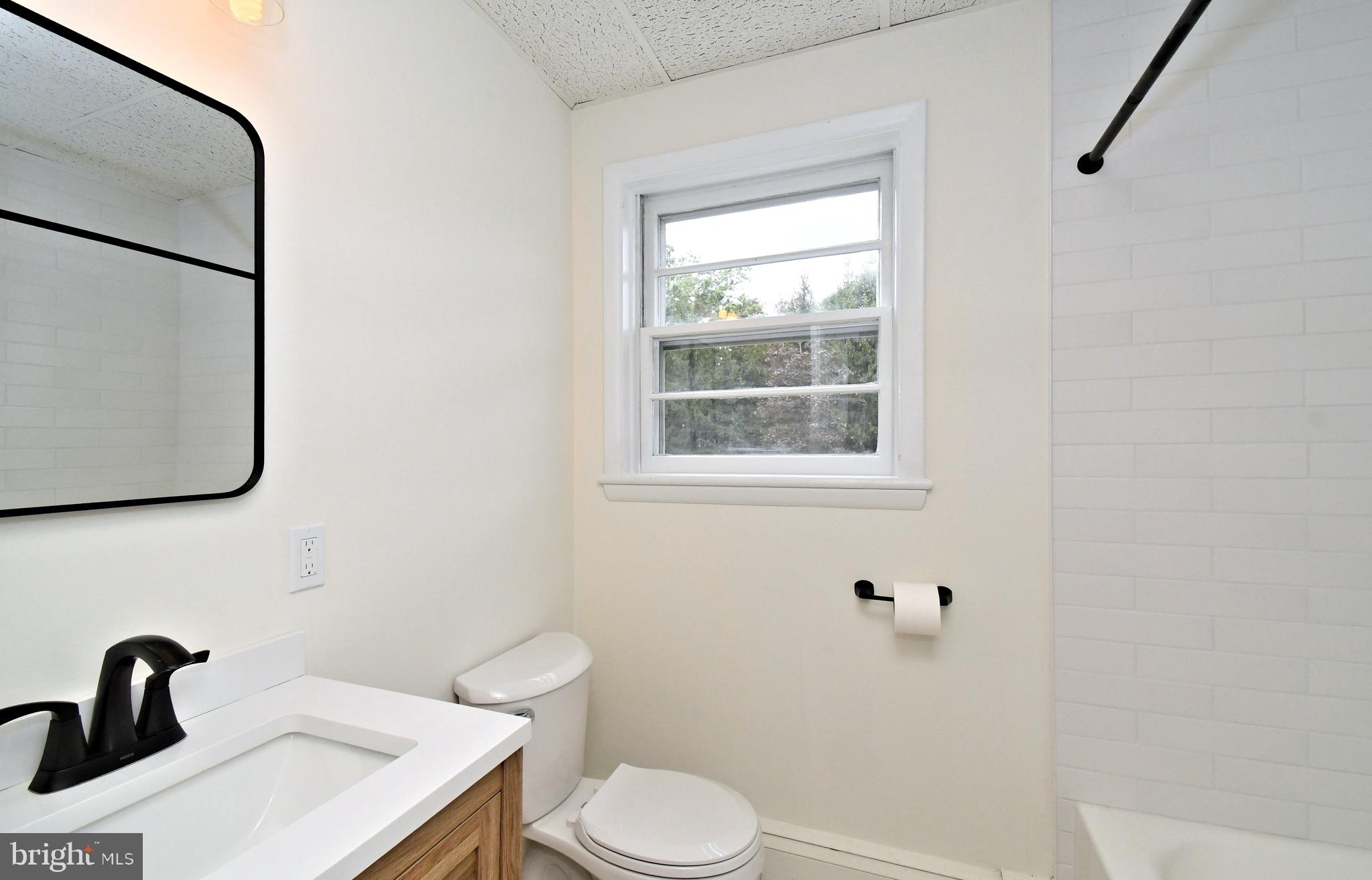 4776 Old Easton Road, Unit 2 Doylestown, PA 18902 - Photo 10 of 25 a bathroom with a toilet sink and mirror