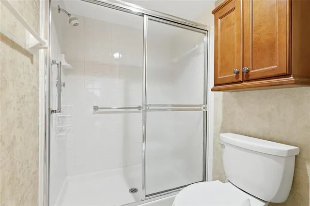 a bathroom with a toilet and a shower