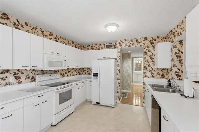 a view of a kitchen with cabinets and washer dryer