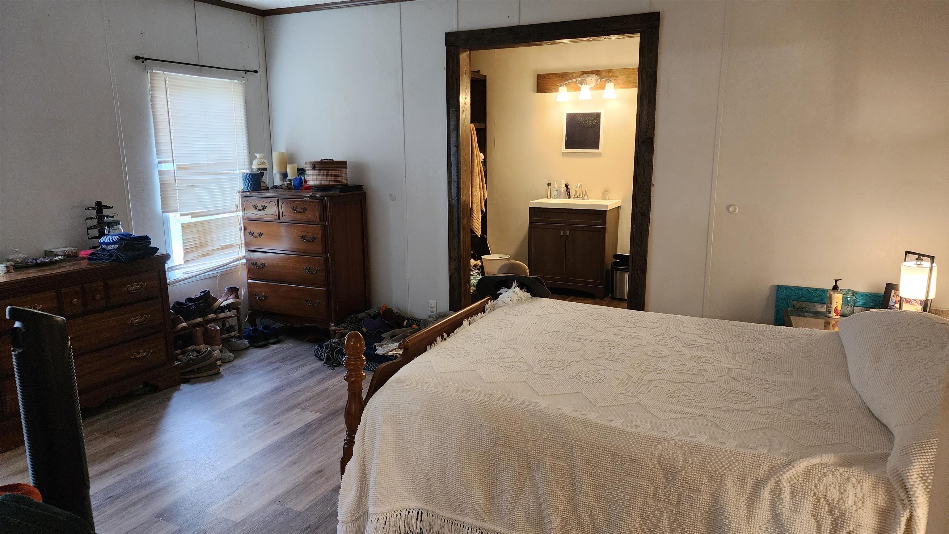 56 Central Curve Road Ripley, TN 38063 - Photo 8 of 14 a bedroom with a bed and wooden floor