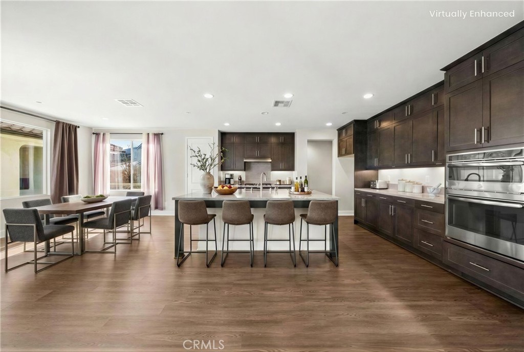 25110 Cherry Ridge Drive Canyon Country, CA 91387 - Photo 22 of 74 a living room with stainless steel appliances kitchen island granite countertop a stove a sink a dining table and chairs with wooden floor