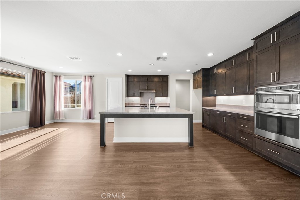 25110 Cherry Ridge Drive Canyon Country, CA 91387 - Photo 23 of 74 a large white kitchen with kitchen island a sink wooden floor and stainless steel appliances