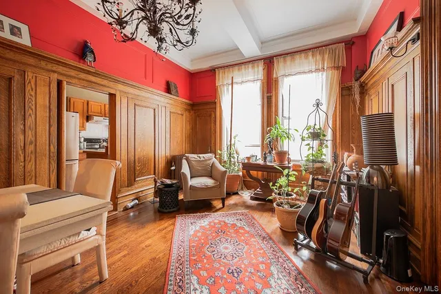 a living room with furniture large window and wooden floor