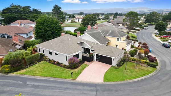 an aerial view of a house with a garden and trees