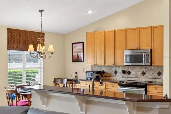 a living room with furniture and a dining table with kitchen view