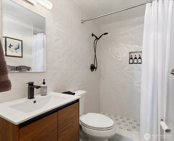a bathroom with a sink a toilet and shower