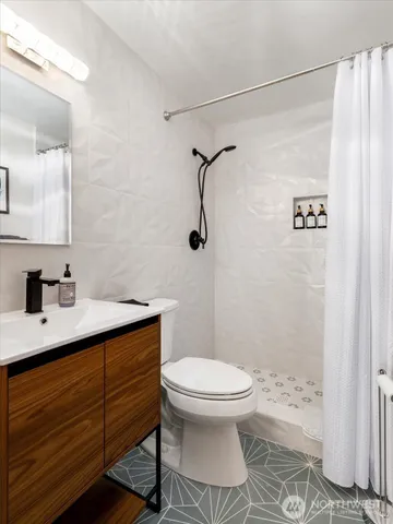 a bathroom with a sink a toilet and shower