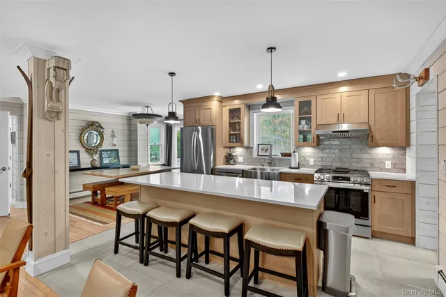 a kitchen with stainless steel appliances granite countertop a refrigerator a oven and white cabinets