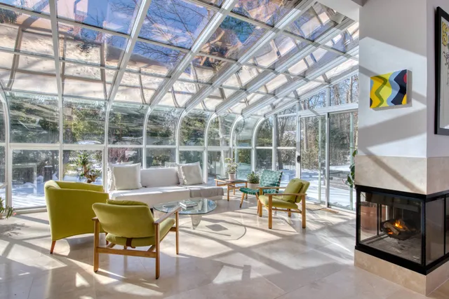 a living room with furniture a fireplace and a floor to ceiling window