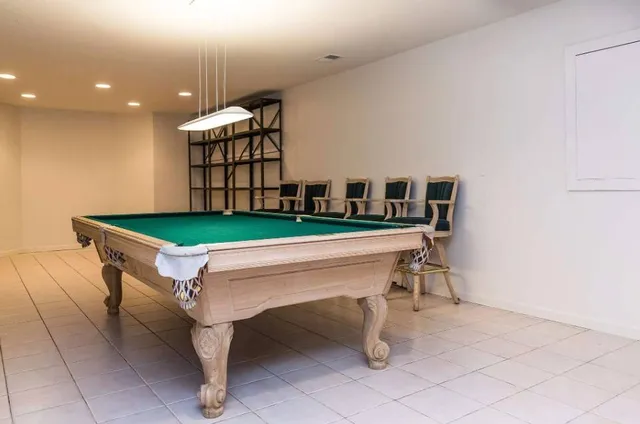 a room with pool table and windows
