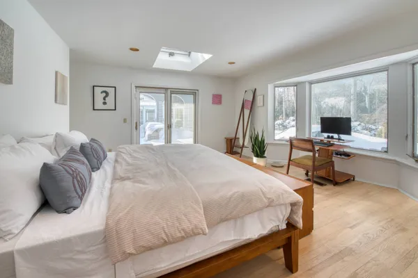 a bedroom with a bed and large windows
