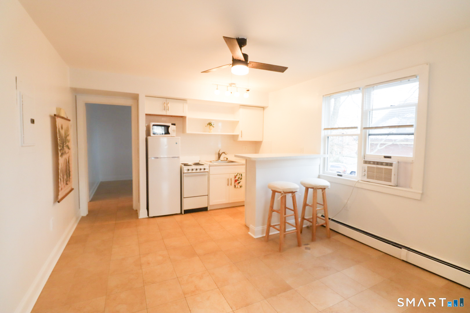 a view of a kitchen with microwave and furniture