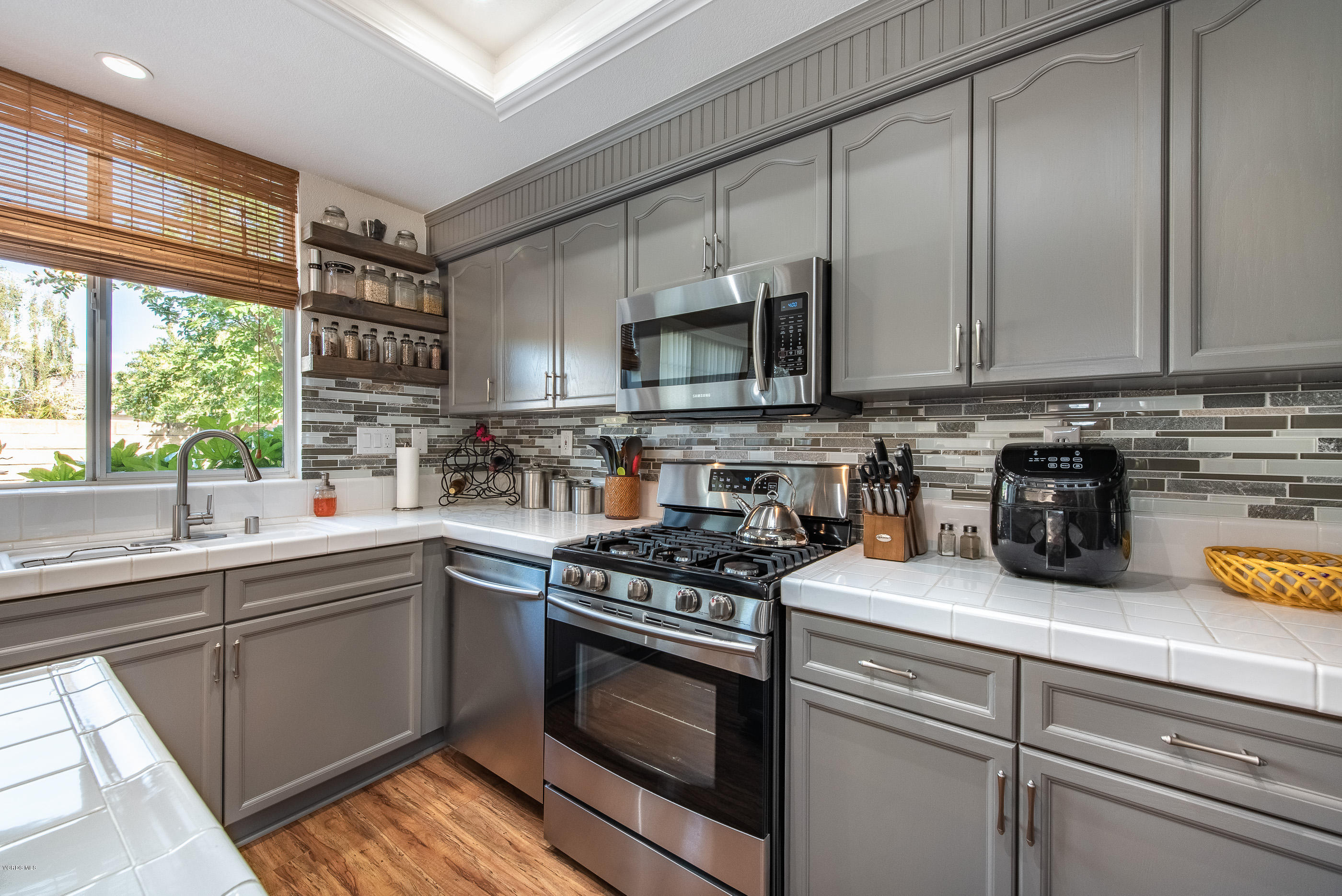 2050 Avila Place Oxnard, CA 93036 - Photo 14 of 31 a kitchen with stainless steel appliances granite countertop a sink a stove and a microwave