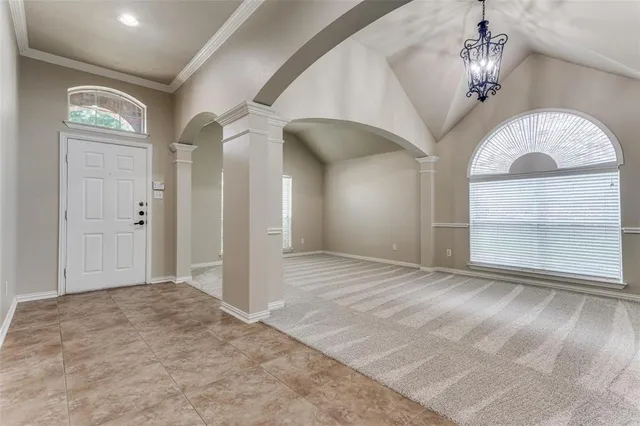 a view of a big room with a chandelier fan and windows
