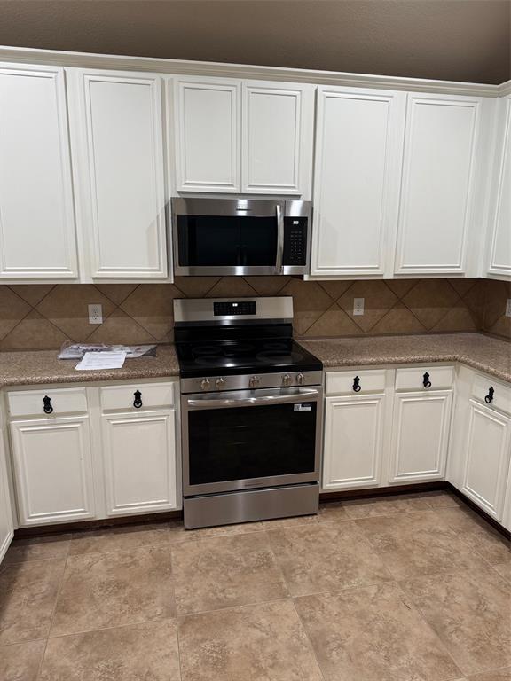 5304 Ridgepass Lane McKinney, TX 75071 - Photo 5 of 10 a kitchen with granite countertop white cabinets and stainless steel appliances