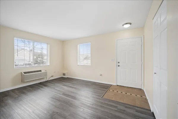 an empty room with wooden floor and windows