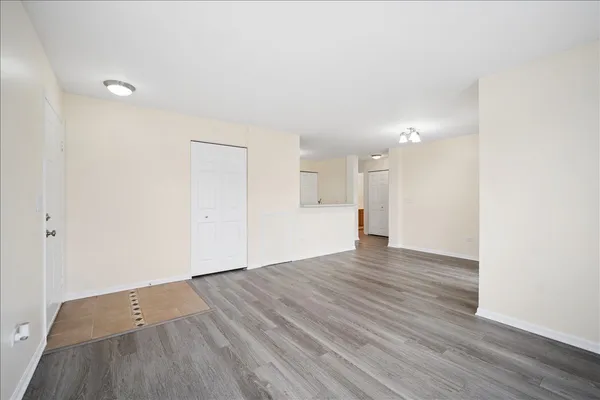 a view of empty room with wooden floor and fan