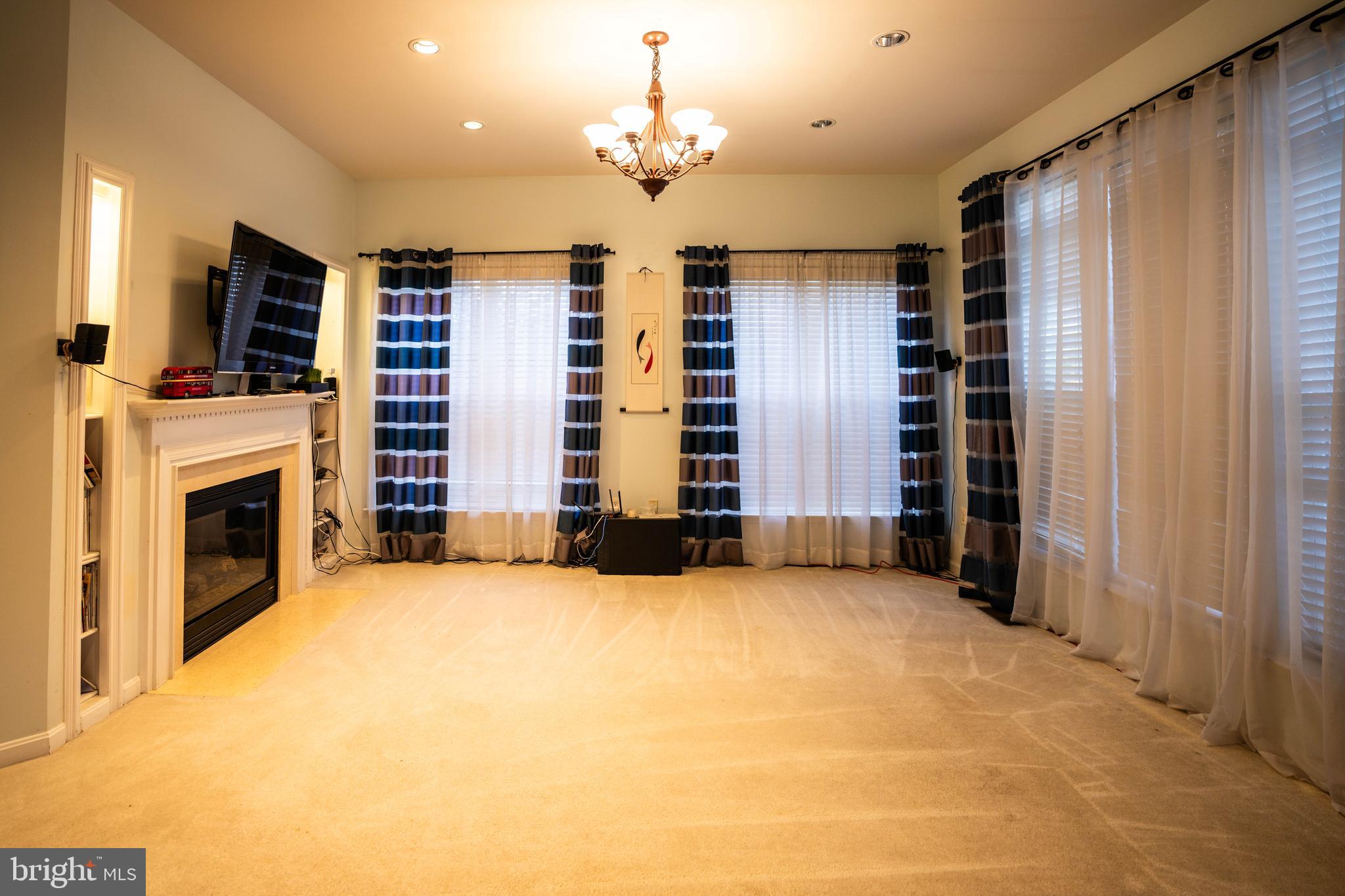 9571 Linnett Hill Drive Lorton, VA 22079 - Photo 7 of 27 an empty room with windows fireplace and windows