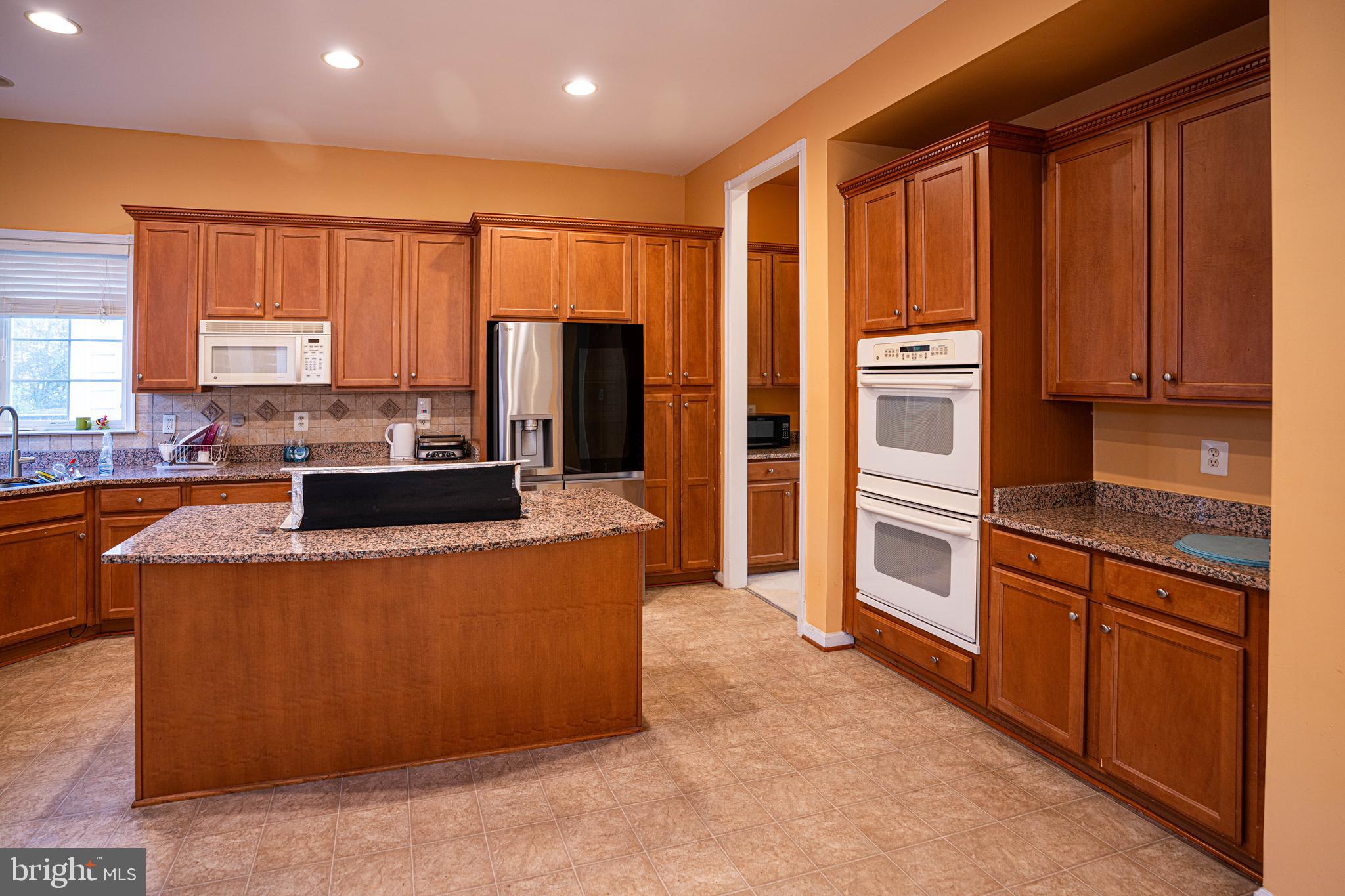 9571 Linnett Hill Drive Lorton, VA 22079 - Photo 9 of 27 a kitchen with stainless steel appliances granite countertop a refrigerator a stove and a sink