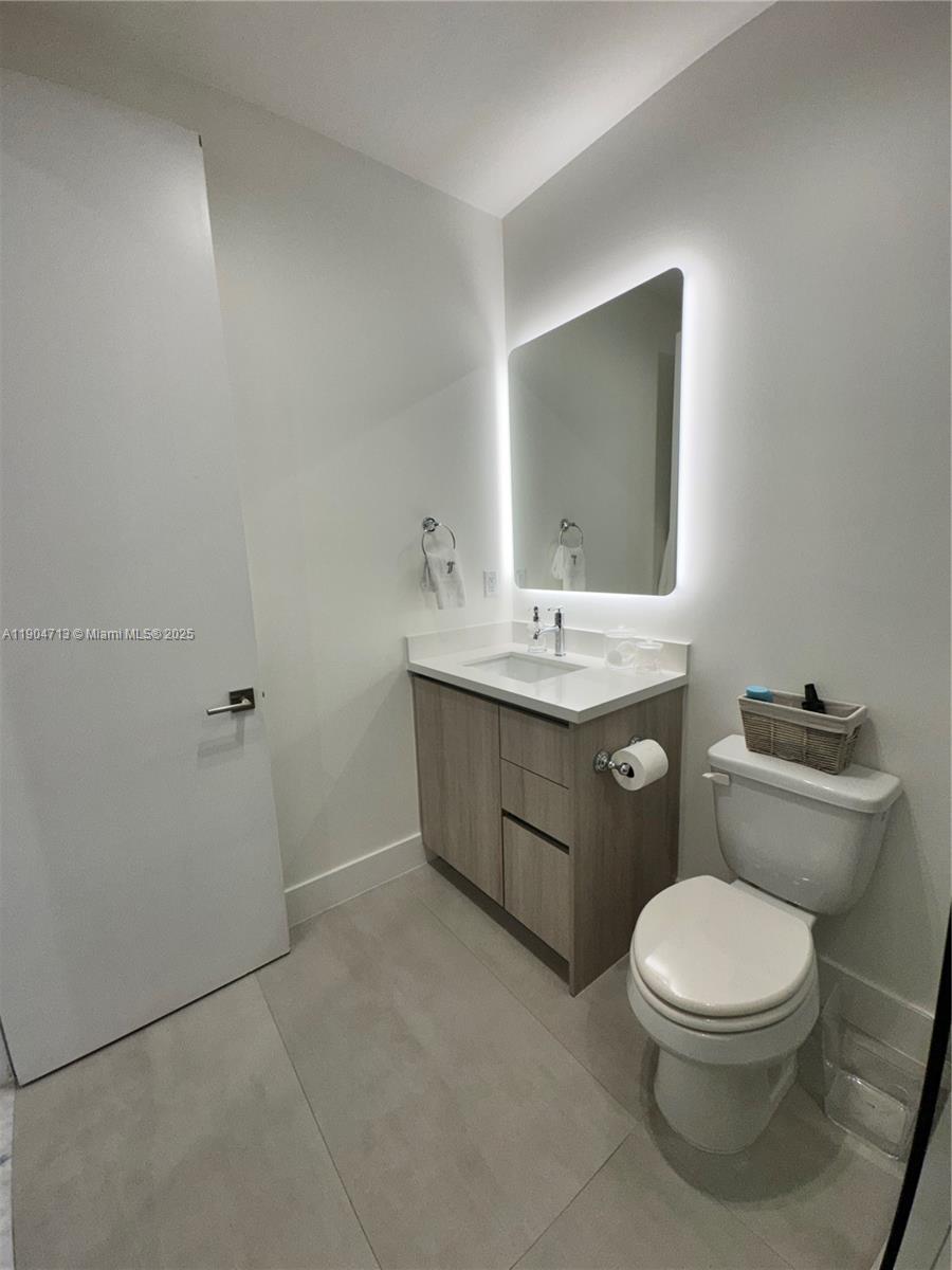 6824 Southwest 80th Street Miami, FL 33143 - Photo 17 of 29 a bathroom with a toilet a sink and mirror
