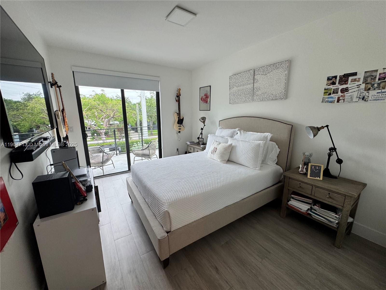 6824 Southwest 80th Street Miami, FL 33143 - Photo 19 of 29 a bedroom with a bed a flat screen tv and a large window