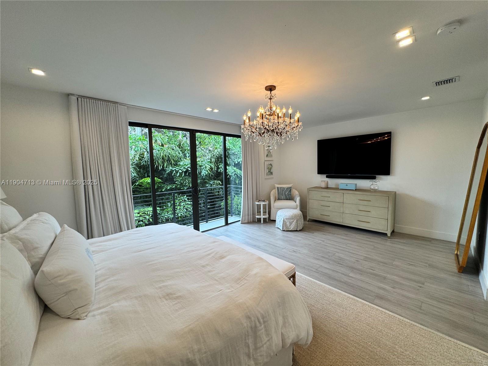 6824 Southwest 80th Street Miami, FL 33143 - Photo 28 of 29 a spacious bedroom with a bed and a flat tv screen on dresser