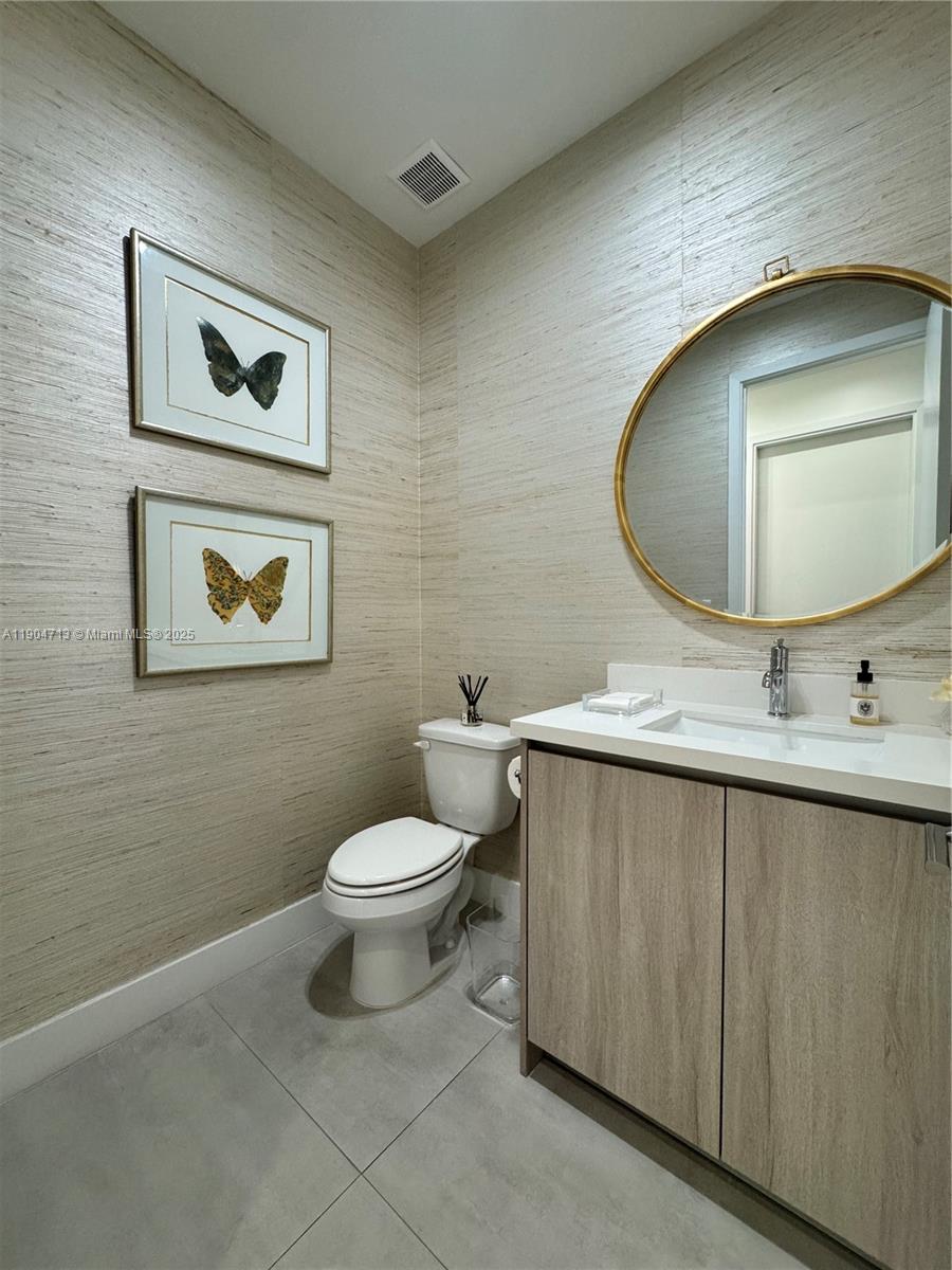 6824 Southwest 80th Street Miami, FL 33143 - Photo 4 of 29 a bathroom with a toilet sink vanity and mirror