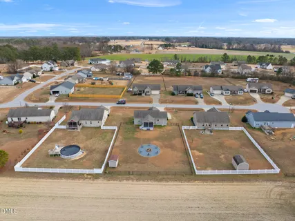 a front view of a house with yard and trees in the background