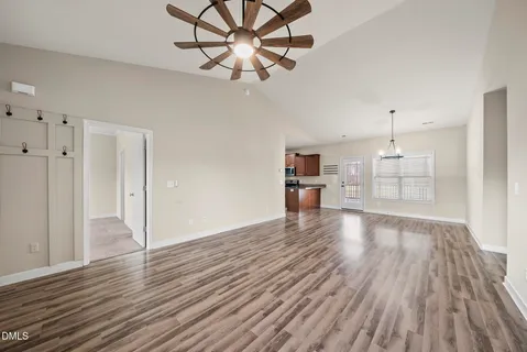 a view of a room with wooden floor staircase and a kitchen
