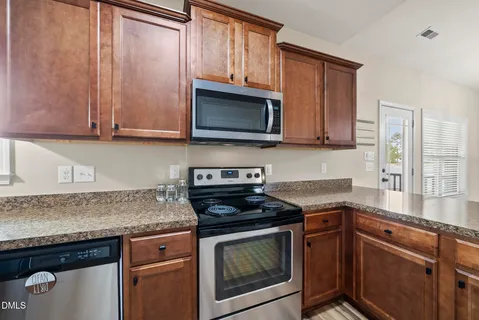 a kitchen with granite countertop cabinets sink and stainless steel appliances