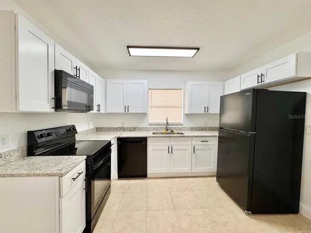 a kitchen with a refrigerator stove microwave and sink