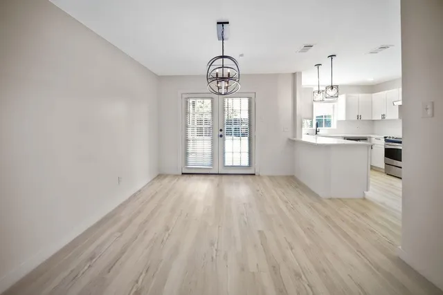 an empty room with wooden floor a fireplace and windows