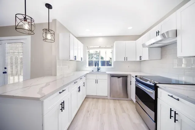 a large kitchen with cabinets and stainless steel appliances
