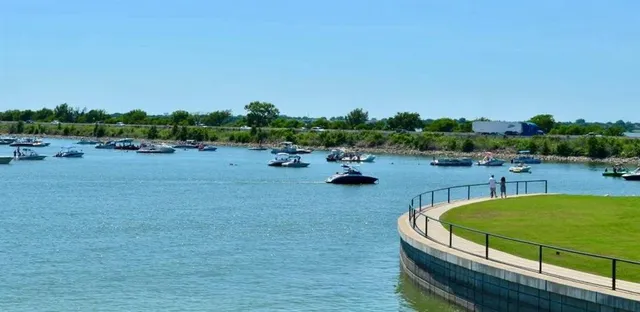 an aerial view of a residential houses with outdoor space and a lake view in back