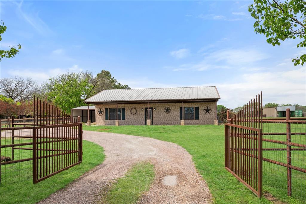 a view of a house with wooden fence next to a yard
