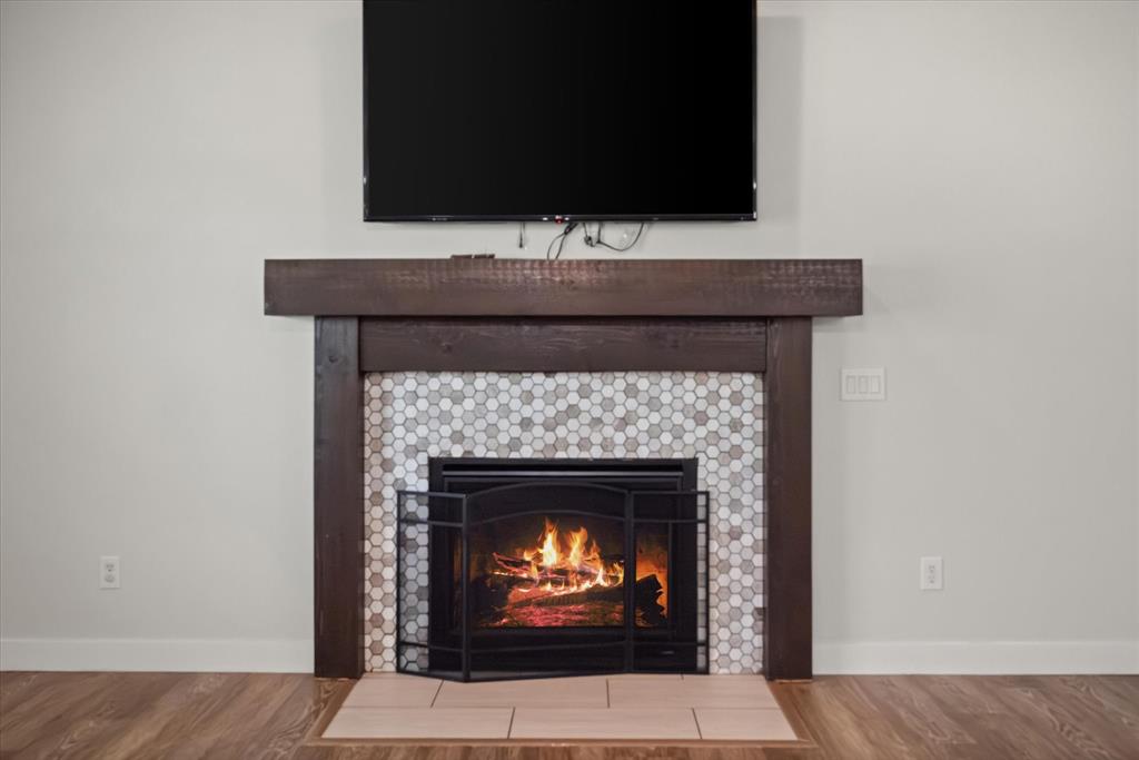 504 Texas Street Tioga, TX 76271 - Photo 19 of 38 a room with a fireplace and a flat screen tv