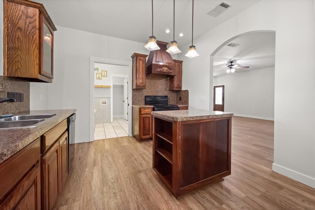 504 Texas Street Tioga, TX 76271 - Photo 25 of 38 a kitchen with stainless steel appliances granite countertop a sink a stove and a wooden floors