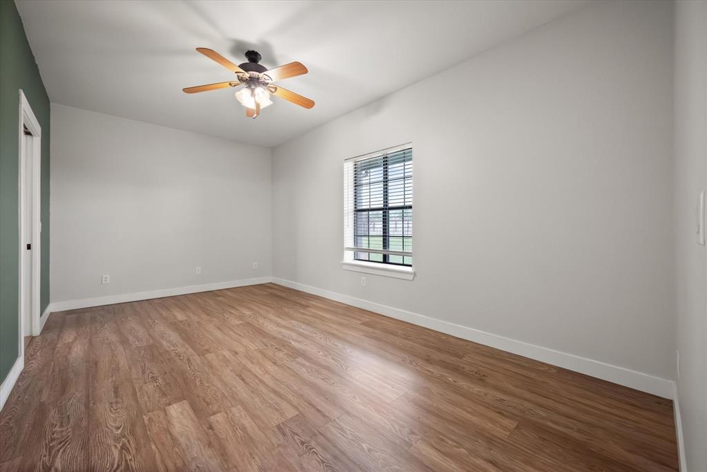 504 Texas Street Tioga, TX 76271 - Photo 36 of 38 an empty room with wooden floor and windows