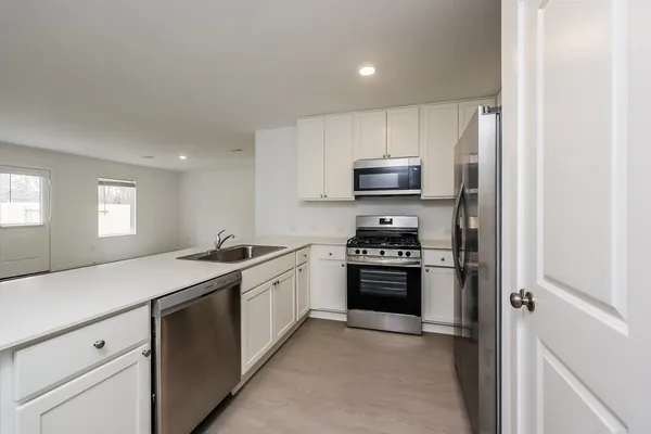 a kitchen with stainless steel appliances granite countertop a sink stove and refrigerator