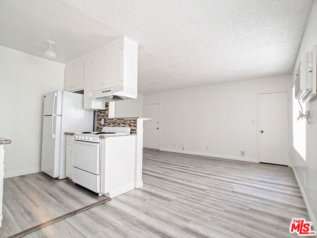 a kitchen with cabinets wooden floor and a sink