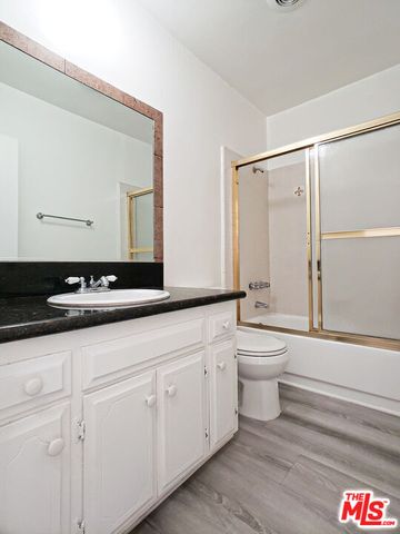 a bathroom with a toilet a sink and a large mirror
