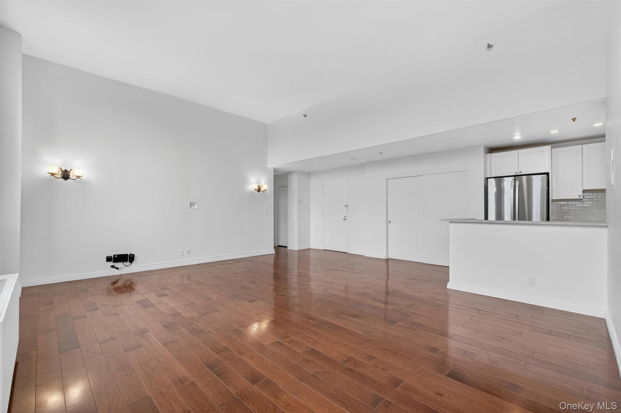 5211 Villa At The Peekskill, NY 10566 - Photo 7 of 19 A view of the living and dining area showcasing the open-concept layout, soaring ceilings, and beautiful hardwood floors.