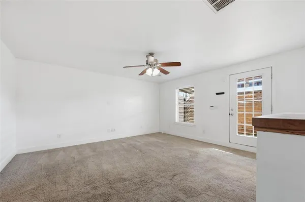 an empty room with windows and cabinet