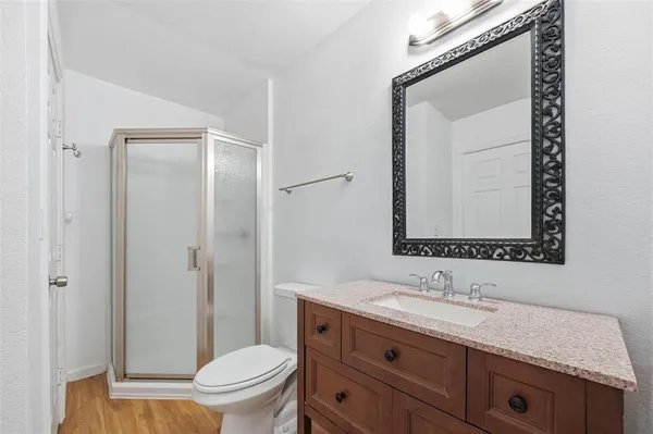 a bathroom with a granite countertop sink a toilet and a mirror