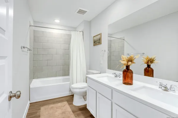 a bathroom with a bathtub shower sink and toilet